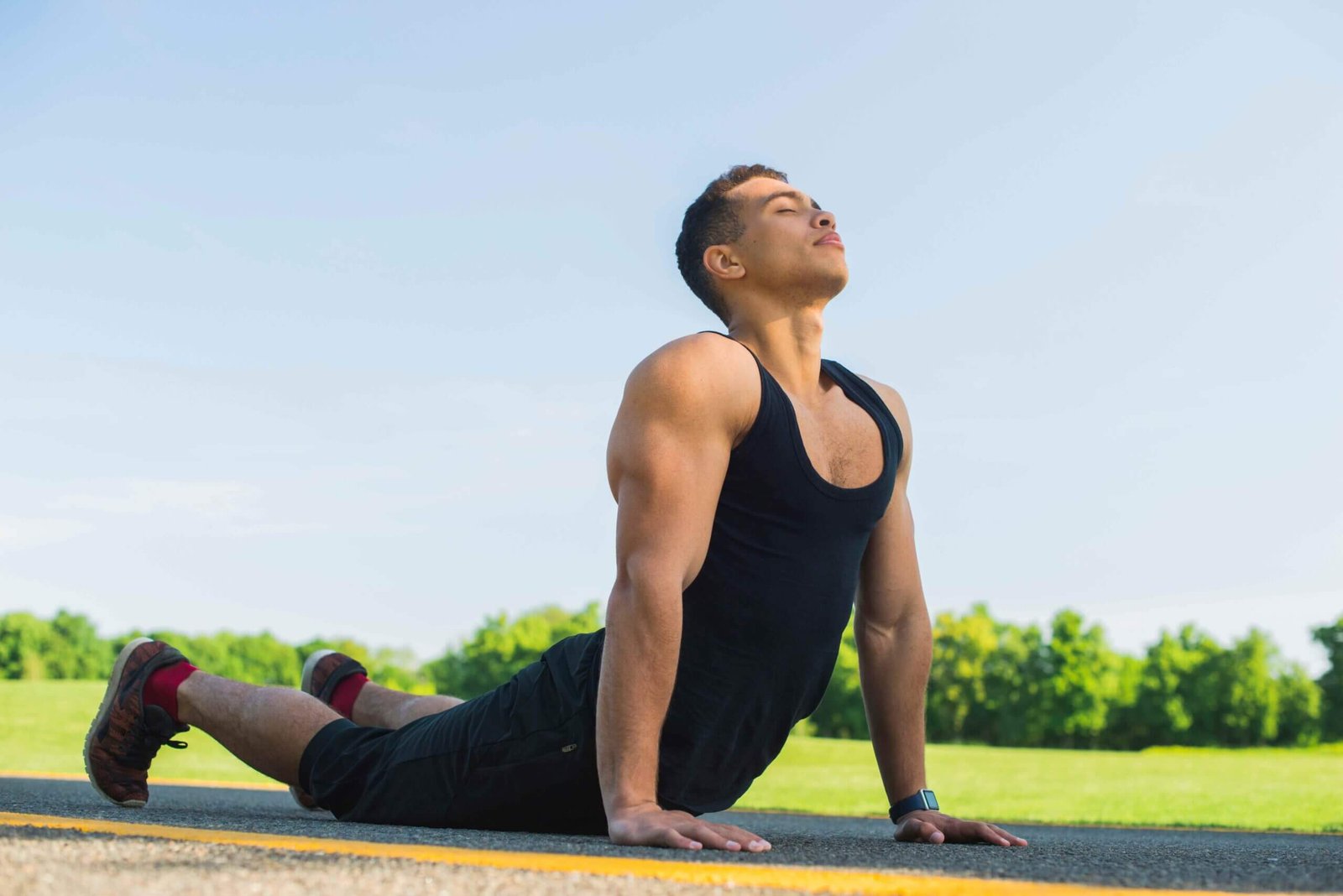 Athletic man practicing yoga outdoors